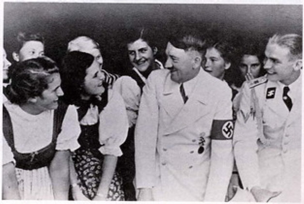 Hitler, facing a girl, looking coy