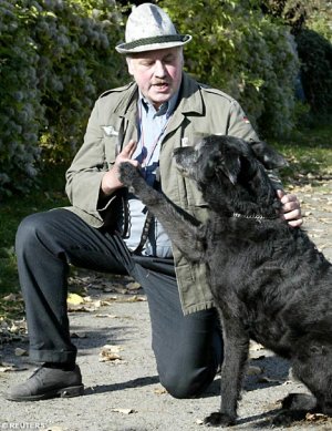 A black dog performs a Nazi salute at its owner’s direction