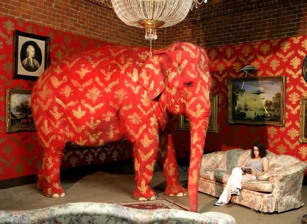 'The Elephant in the Room as seen at one of Banksy's exhibitions. Here a real live elephant was used, painted with children's face paint.'