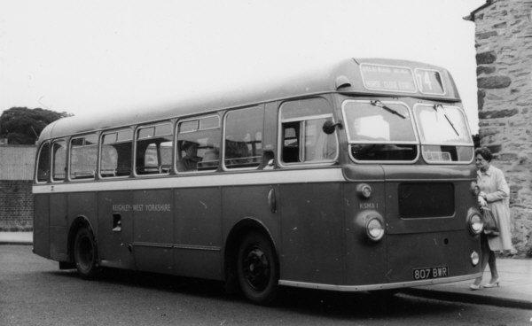 An old Keighley bus with a woman passenger getting on