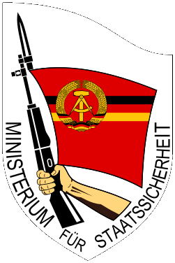 The Stasi’s crest: the words ‘Ministerium fuer Staatssicherheit’ (Ministry for State Security) under an arm holding aloft a rifle from which extends an East German flag