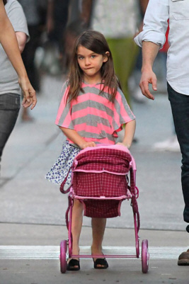 Suri Cruise pushing a doll’s pram