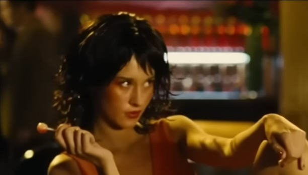 A woman keenly watches the reaction to her open legs. Scene from 'Revolver' (2005)